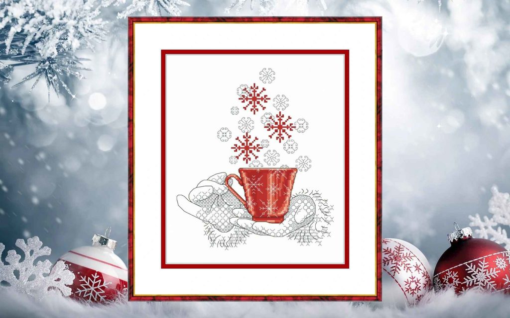 Cross stitch pattern of a red cup in hands with falling snowflakes, cozy winter embroidery design on white background.